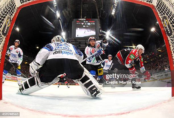 Christopher Minard of Koeln and Alexander Dueck of Schwenningen battle for the puck during the DEL match between Koelner Haie and Schwenninger Wild...