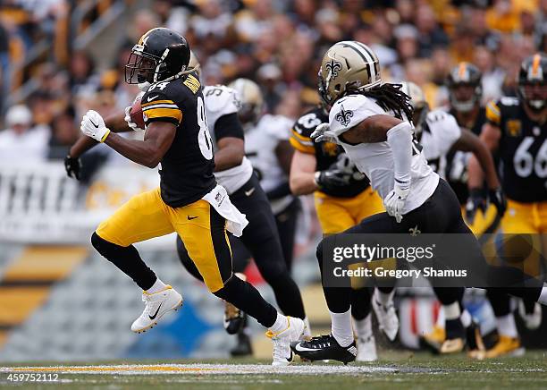 Antonio Brown of the Pittsburgh Steelers carries the ball in front of Pierre Warren of the New Orleans Saints at Heinz Field on November 30, 2014 in...