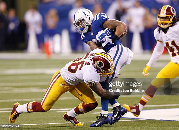 Daniel Herron of the Indianapolis Colts fumbles on the tackle by Perry Riley of the Washington Redskins in the first half of the game at Lucas Oil...