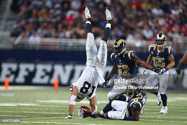 Andre Holmes of the Oakland Raiders is tackled by E.J. Gaines of the St. Louis Rams in the second quarter at the Edward Jones Dome on November 30,...