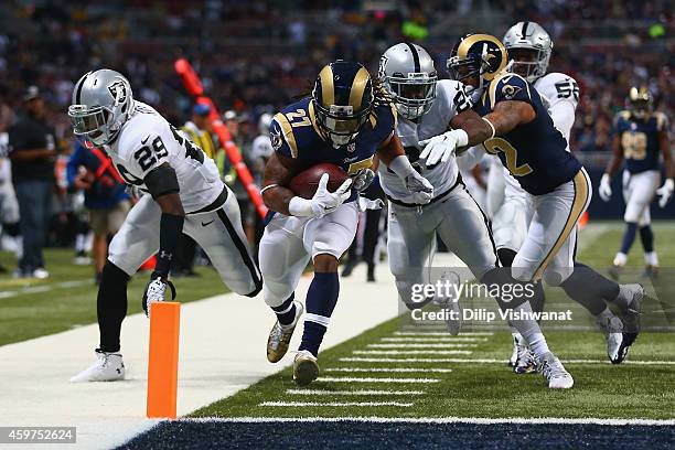 Tre Mason of the St. Louis Rams scores a touchdown against Brandian Ross and D.J. Hayden of the Oakland Raiders in the first quarter at the Edward...