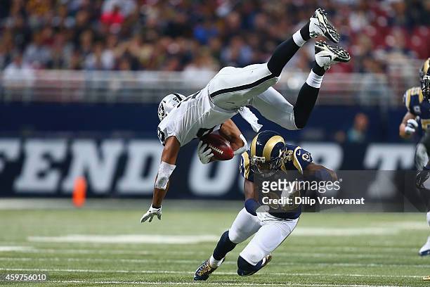 Andre Holmes of the Oakland Raiders is tackled by E.J. Gaines of the St. Louis Rams in the second quarter at the Edward Jones Dome on November 30,...