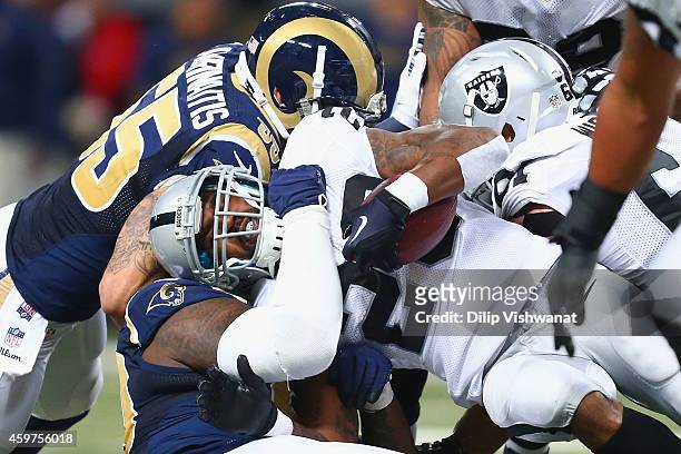 Darren McFadden of the Oakland Raiders is tackled by James Laurinaitis of the St. Louis Rams in the first quarter at the Edward Jones Dome on...