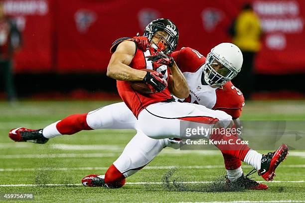 Eric Weems of the Atlanta Falcons is tackled by Antonio Cromartie of the Arizona Cardinals after a catch during the first half at the Georgia Dome on...