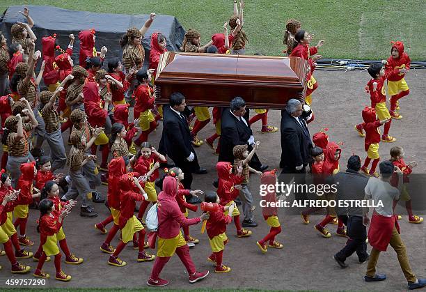 The coffin of Mexican comedian Roberto Gomez Bolanos is carried followed by children disguised as his characters "El Chapulin Colorado" and "El Chavo...