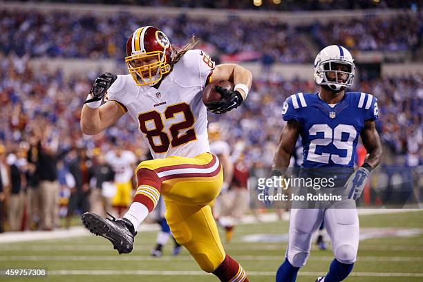 Logan Paulsen of the Washington Redskins runs into the end zone on a 16-yard touchdown reception ahead of Mike Adams of the Indianapolis Colts in the...