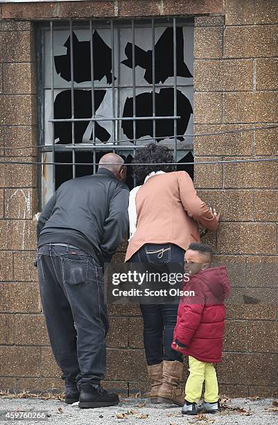 People look in a window of the fire-damaged Flood Christian Church on November 30, 2014 in Ferguson, Missouri. Michael Brown, the Father of Michael...