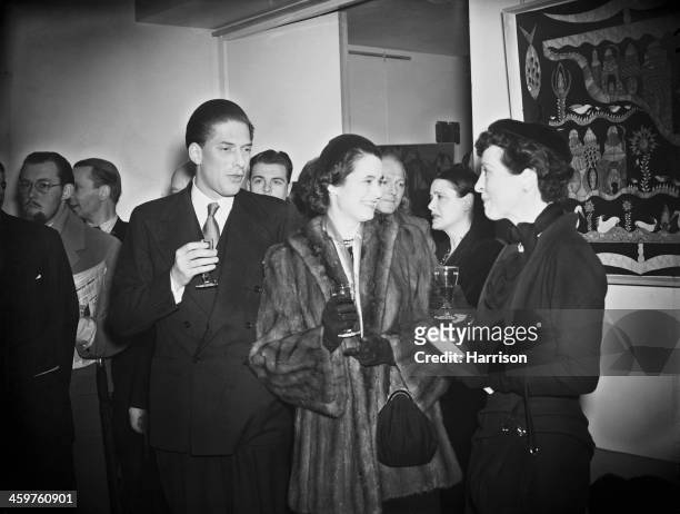 George Lascelles, 7th Earl of Harewood and his wife Marion Stein, Countess of Harewood talking to English stage actress Margaret Rawlings at the...