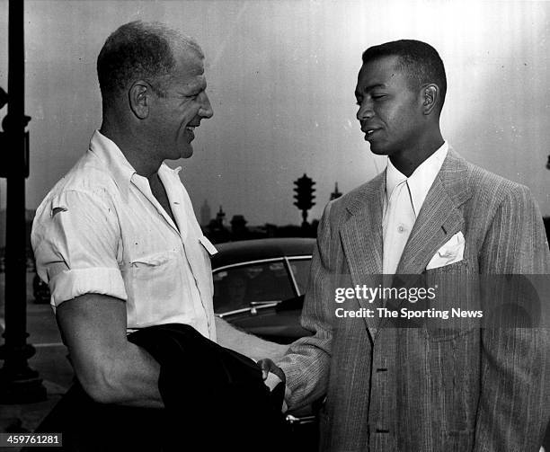 Larry Doby , the American league's first black player, shakes hands with his new boss, President Bill Veeck of the Cleveland Indians', after Doby...