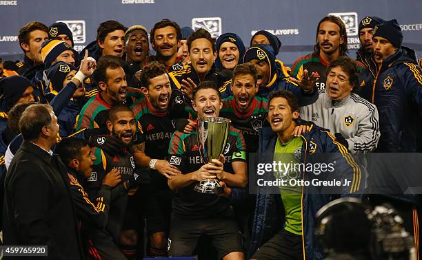 Robbie Keane of the Los Angeles Galaxy hoists the Western Conference trophy after the Galaxy advanced to the MLS cup against the Seattle Sounders FC...