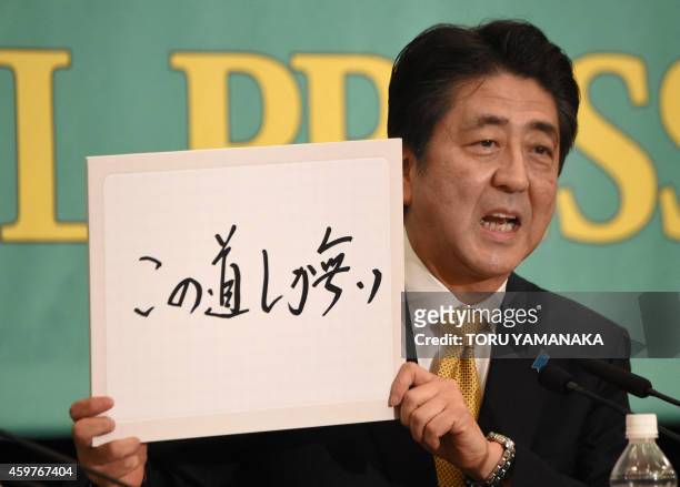 The ruling Liberal Democratic Party President and Prime Minister Shinzo Abe speaks as he holds a flip in which he writes his slogan 'This is the Only...