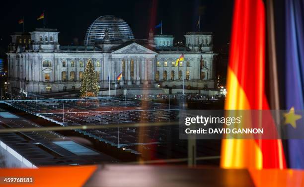 The Reichstag is seen through the window in front of which German Chancellor Angela Merkel recorded her annual New Year's speech at the Chancellery...