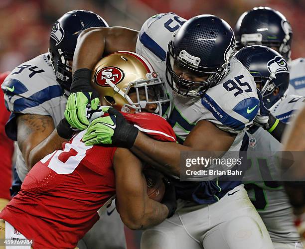 Defensive end Demarcus Dobbs of the Seattle Seahawks wraps up running back Carlos Hyde of the San Francisco 49ers for a loss of a yard in the first...