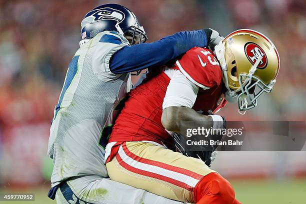 Cornerback Tharold Simon of the Seattle Seahawks tackles wide receiver Stevie Johnson of the San Francisco 49ers on an eight-yard gain in the last...