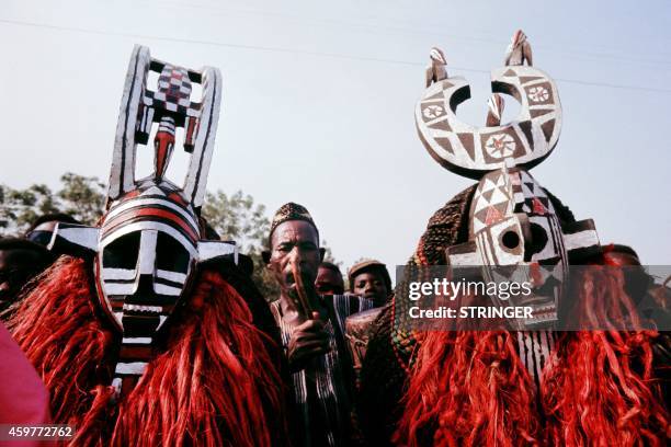 Picture released on November 1972 in Ouagadougou of Burkinabe dancers and musiciens wearing traditional masks during French President Georges...