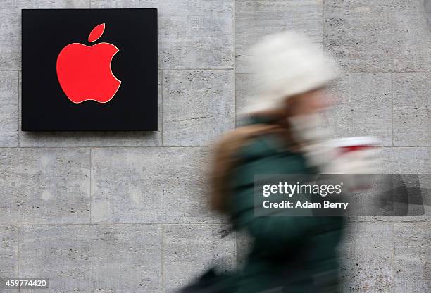 Pedestrian passes a red Apple logo at the Apple Store on December 1, 2014 in Berlin, Germany. On World AIDS Day, December 1, Apple is donating a...