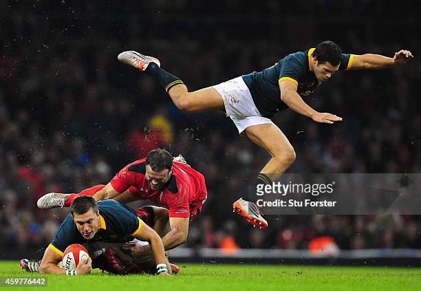 Wales centre Jamie Roberts tackles Handre Pollard as Jan Serfontein of South Africa goes flying during the Autumn international match between Wales...