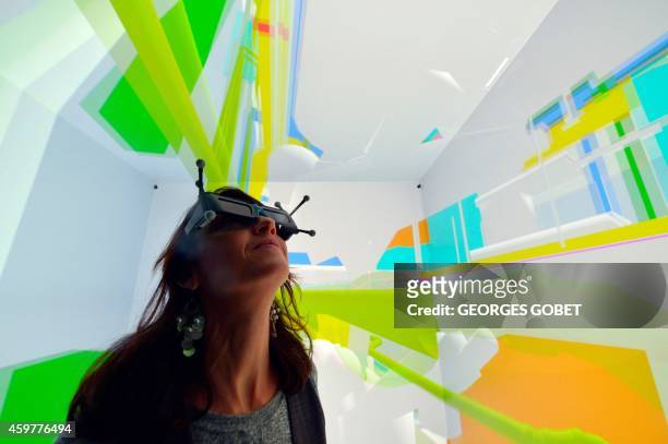 Woman wearing 3D glasses tests a Cave Automatic Virtual Environment virtual reality theatre during its presentation at the Industrial Centre for...