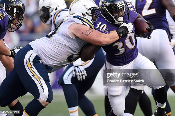 Running back Bernard Pierce of the Baltimore Ravens breaks a tackle against the San Diego Chargers in the second half at M&T Bank Stadium on November...