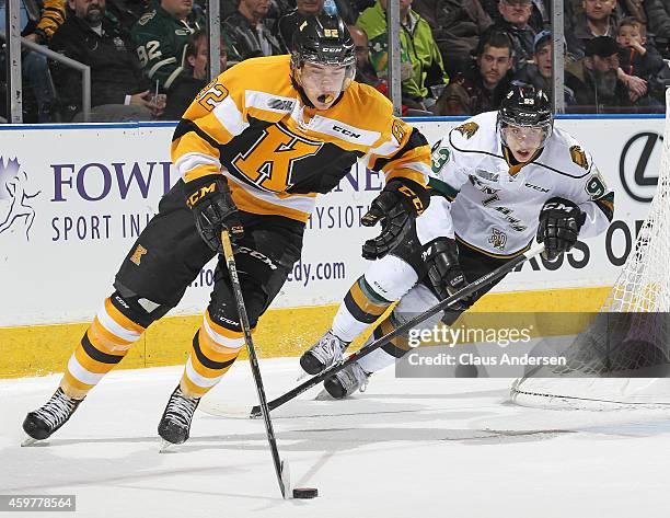 Juho Lammikko of the Kingston Frontenacs skates away from a checking Mitchell Marner of the London Knights in an OHL game at Budweiser Gardens on...