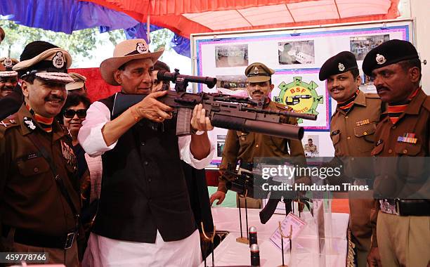 Union Home Minister Rajnath Singh try his hand on the weapons on display on 49th Raising day of BSF at Chawala Camp on December 1, 2014 in New Delhi,...