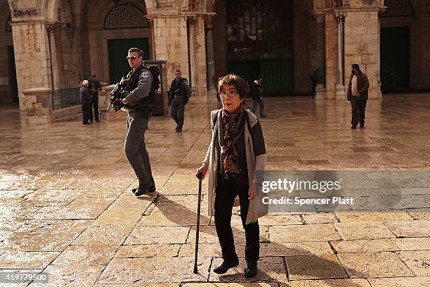 An Israeli border police officer patrols beside tourists near the Dome of the Rock at the Al-Aqsa mosque compound in the Old City on December 01,...