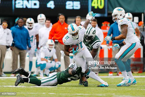 Mike Wallace of the Miami Dolphins in action against Dawan Landry and DeMario Davis of the New York Jets on December 1, 2013 at MetLife Stadium in...