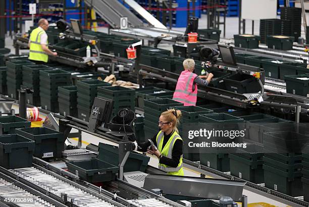 Workers sort customer "click and collect" orders into crates destined for John Lewis stores, at the John Lewis Plc semi-automated distribution centre...