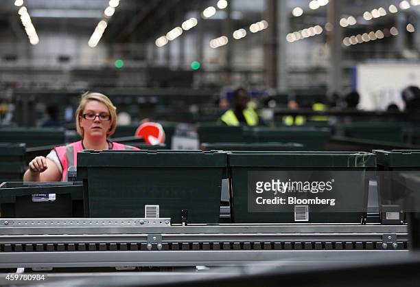 Worker sorts customer "click and collect" orders into crates destined for John Lewis stores, at the John Lewis Plc semi-automated distribution centre...