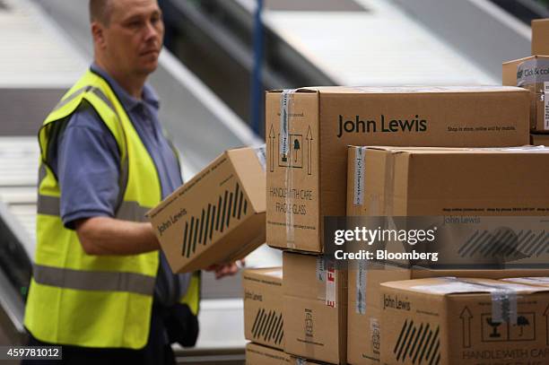 Worker prepares boxed customer orders ahead of shipping from the John Lewis Plc semi-automated distribution centre in Milton Keynes, U.K., on Monday,...