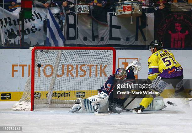 Mitja Robar of Krefeld Pinguine scores past Niklas Treutle of EHC Red Bull Muenchen during the DEL match between EHC Red Bull Muenchen and Krefeld...