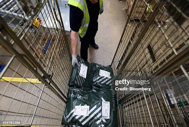 Worker prepares packaged customer orders ahead of shipping from the John Lewis Plc semi-automated distribution centre in Milton Keynes, U.K., on...