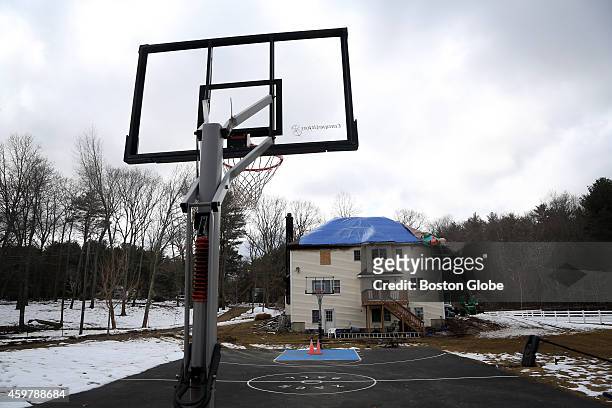 Workers board up the destroyed home of star Syracuse University guard Michael Carter-Williams. The basketball court in Carter-Williams's backyard...