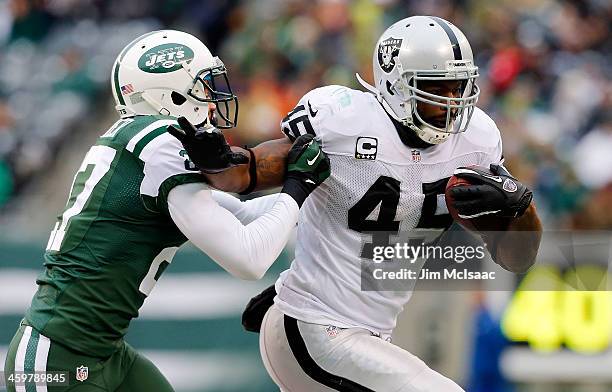 Marcel Reece of the Oakland Raiders in action against Dee Milliner of the New York Jets on December 8, 2013 at MetLife Stadium in East Rutherford,...