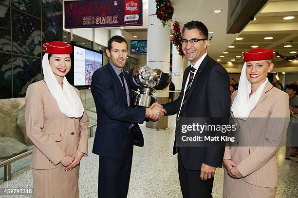 Former Socceroos Brett Emerton hands over the Asian Cup to Chief Operating Officer of the Asian Cup 2015 Organising Committee Mark Falvo after its...