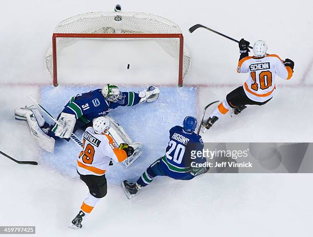Chris Higgins of the Vancouver Canucks and Scott Hartnell of the Philadelphia Flyers looks on as Brayden Schenn of the Philadelphia Flyers scores on...