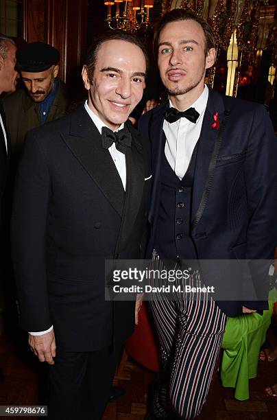 John Galliano and Alexis Roche attend a party in celebration of Edward Enninful in The Oscar Wilde Bar, Hotel Cafe Royal, on December 1, 2014 in...