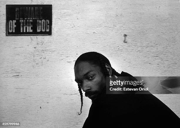 Rapper Snoop Dogg poses for a portrait session underneath a sign that warns "Beward Of The Dog" in an alley oustide of Encore Studios in 1998 in...