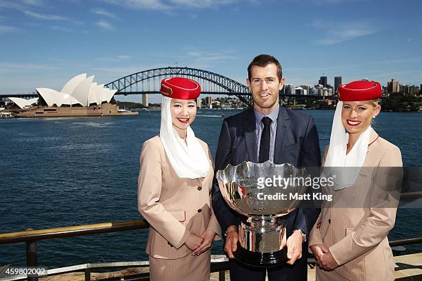 Former Socceroos Brett Emerton and Emirates cabin crew pose with the Asian Cup trophy during the Asian Cup Trophy Tour at Sydney Harbour on December...