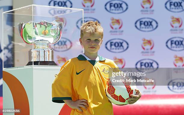 Young footballers pose next to the Asian Cup trophy during the Fox Sports Asian Cup coverage launch at Bondi Beach on December 2, 2014 in Sydney,...