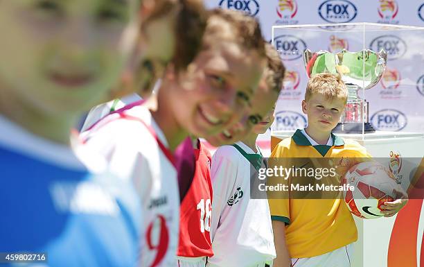 Young footballers pose next to the Asian Cup trophy during the Fox Sports Asian Cup coverage launch at Bondi Beach on December 2, 2014 in Sydney,...