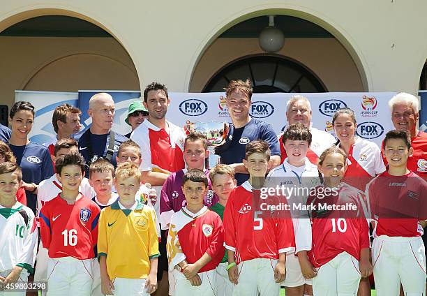 Former Socceroos players and Fox Sports presenters pose with the Asian Cup trophy during the Fox Sports Asian Cup coverage launch at Bondi Beach on...