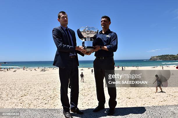 Former Australian Socceroos football players Brett Emerton and John Aloisi pose with the Asian Cup trophy at the Fox Sports Asian Cup coverage launch...