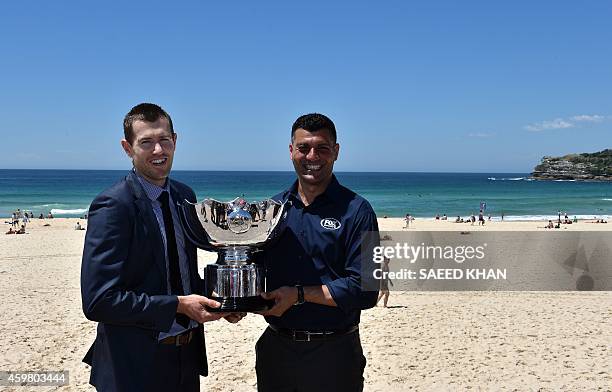 Former Australian Socceroos football players Brett Emerton and John Aloisi pose with the Asian Cup trophy at the Fox Sports Asian Cup coverage launch...