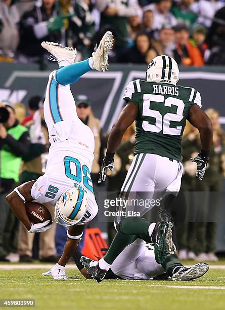 Dawan Landry of the New York Jets tackles Dion Sims of the Miami Dolphins after a catch in the first half during their game at MetLife Stadium on...
