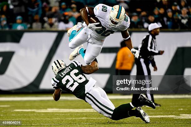 Dawan Landry of the New York Jets tackles Dion Sims of the Miami Dolphins after a catch in the first half during their game at MetLife Stadium on...