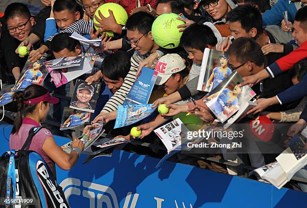 Na Li of China signs autographs for fans after winning her match against Vera Zvonareva of Russia on day four of the WTA Shenzhen Open at Shenzhen...