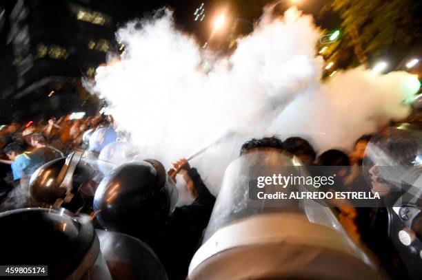 Riot police fight with a group of demonstrators during a protest demanding justice in the case of the 43 missing students from Ayotzinapa, on...