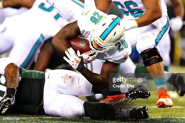 Lamar Miller of the Miami Dolphins scores a 4 yard touchdown in the fourth quarter to tie the game against the New York Jets at MetLife Stadium on...