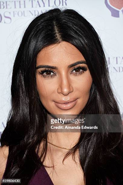 Television personality Kim Kardashian poses after raising a toast for the Elizabeth Taylor Foundation/World AIDS Day at The Abbey on December 1, 2014...